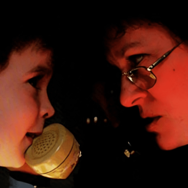 Child and adult face each other closely